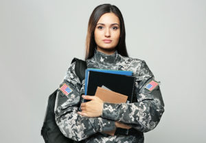 Veteran wearing backpack and holding notebooks for education